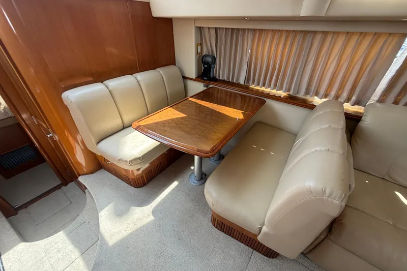 Slide: The Image of Interior of 2005 Carver 396 Aft Cabin Motor Yacht with beige seating and wooden table. - 8