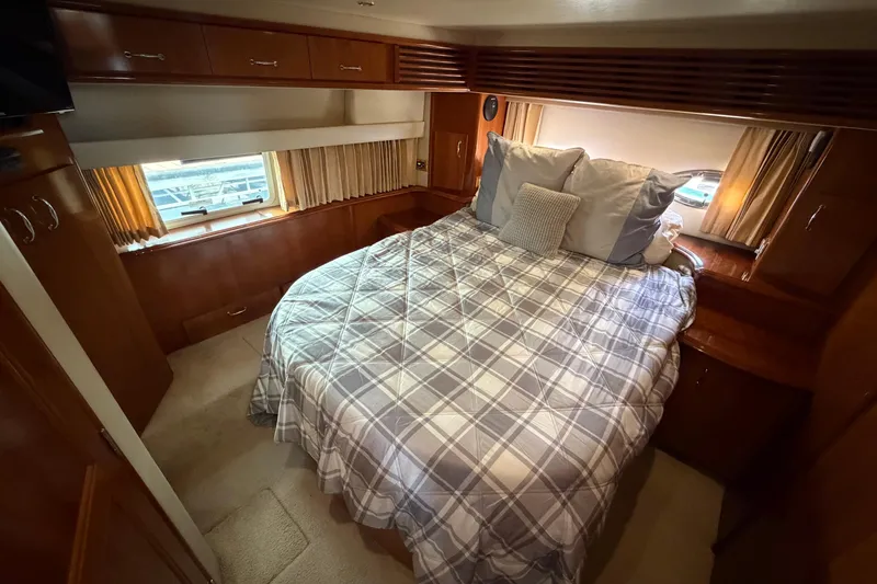 Slide: The Image of Luxurious bedroom in 2005 Carver 396 Aft Cabin Motor Yacht with cozy bedding and wood accents. - 14