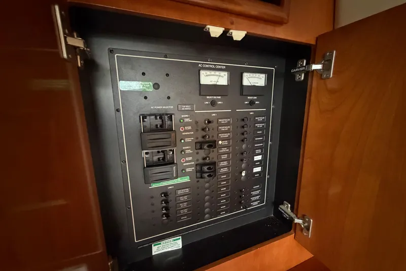 Slide: The Image of Electrical control panel inside 2005 Carver 396 Aft Cabin Motor Yacht, featuring switches and meters. - 19