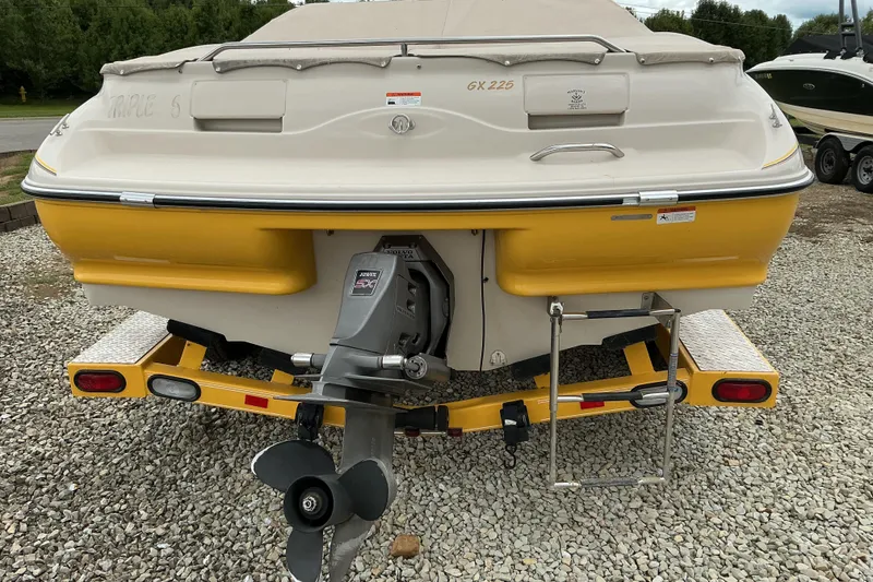 Slide: The Image of 2003 Glastron GX225 boat on trailer, rear view, yellow and white design. - 4