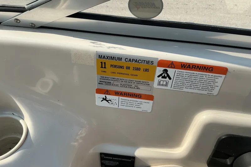 Slide: The Image of 2003 Glastron GX 225 boat capacity and safety warning labels on interior panel. - 11