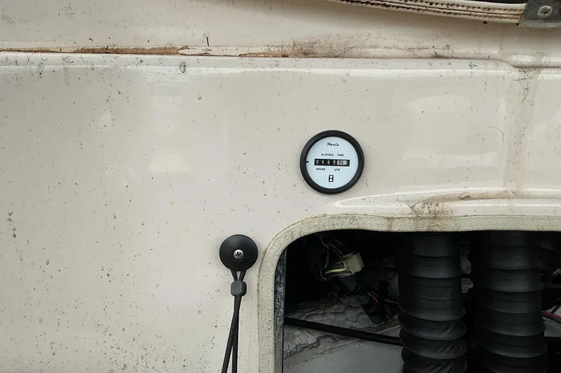 Slide: The Image of 2003 Glastron GX225 boat dashboard with hour meter and wiring visible. - 7