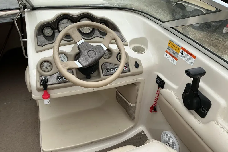 Slide: The Image of 2003 Glasstron GX225 boat dashboard with steering wheel and control panel. - 5