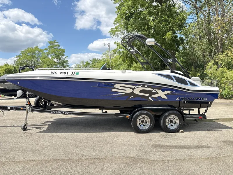 Slide: The Image of A blue and white 2015 Starcraft 211 SCX on a trailer. It features a sleek design. - 4