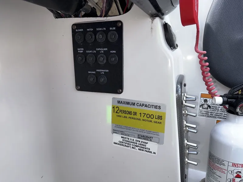 Slide: The Image of Close-up of a boat panel with capacity label and fire extinguisher. - 25