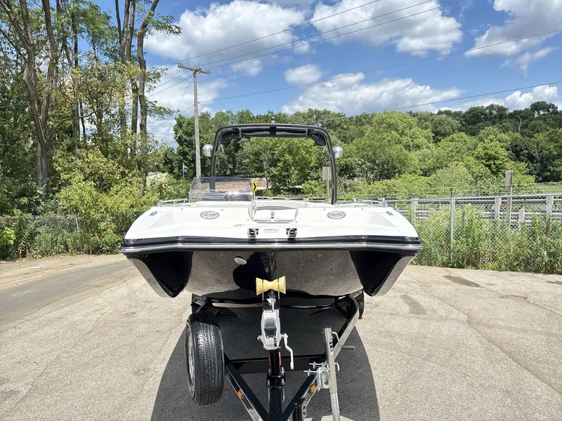 Slide: The Image of A 2015 Starcraft 211 SCX boat on a trailer, surrounded by trees and a fence. - 2