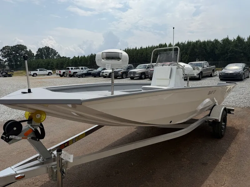 Slide: The Image of A white G3 Bay 17 boat on a trailer, surrounded by cars and trees in the background. - 4
