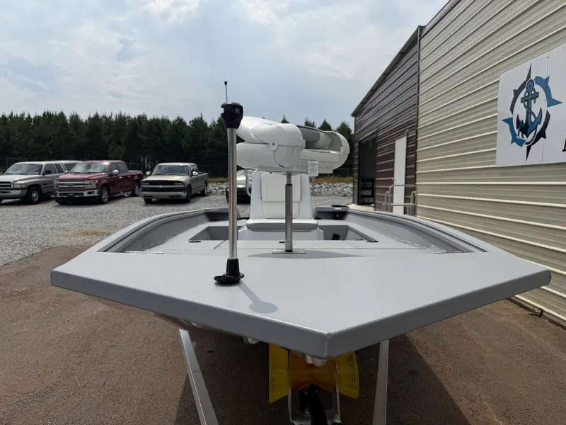 Slide: The Image of A G3 Bay 17 boat with a white deck, parked next to a building. Cars are visible in the background. - 3