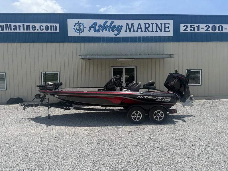 The Image of A 2024 Nitro Z19 boat on a trailer in front of a building with "Ashley Marine" signage. - 1