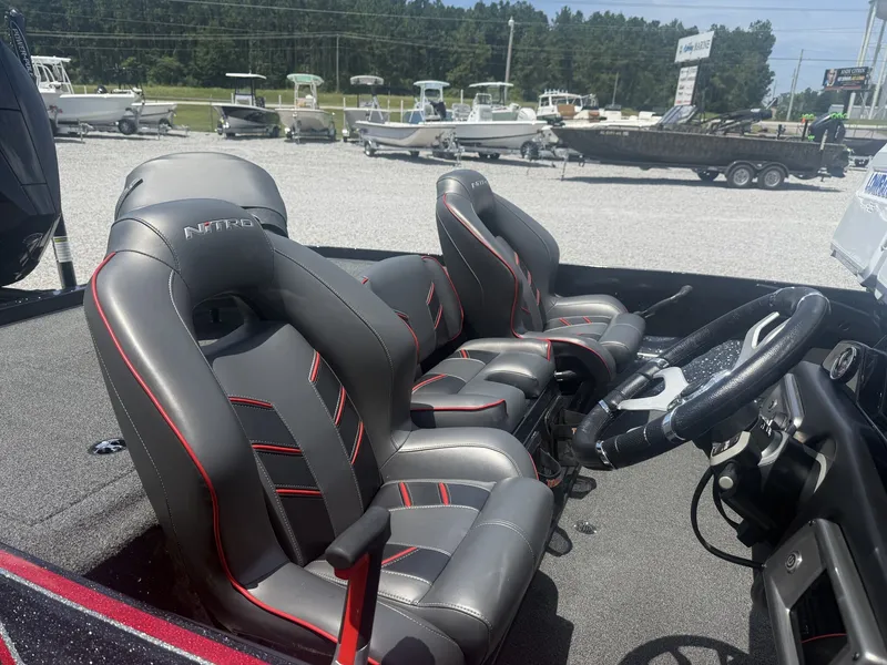 Slide: The Image of Two padded seats in a modern boat with steering wheel and controls, surrounded by other boats. - 3
