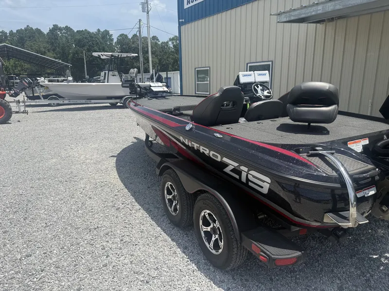 Slide: The Image of A black Nitro Z19 boat on a trailer in a gravel lot in front of a building. - 5