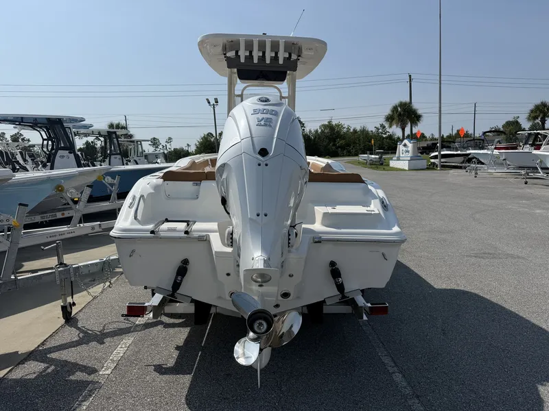 Slide: The Image of A 2027 Key West 239 FS boat with a powerful outboard motor, parked on an asphalt lot. - 7