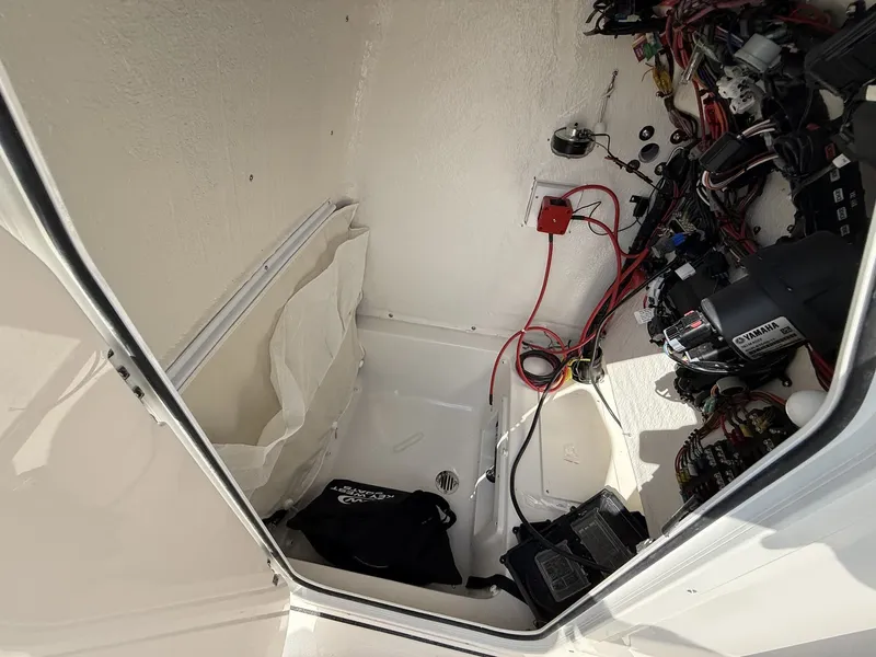 Slide: The Image of A view inside a boat's storage area with wires, a battery, and a small drain. - 10