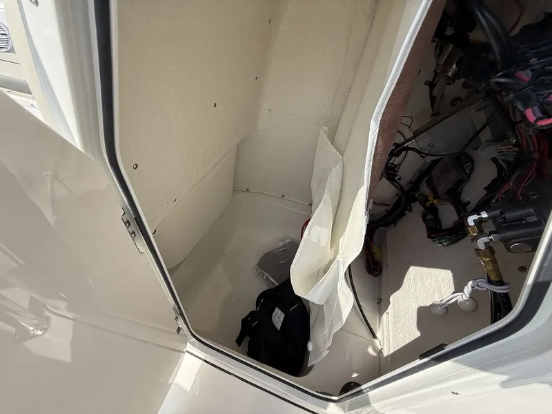 Slide: The Image of An open storage compartment in the boat with cables and a bag. - 10
