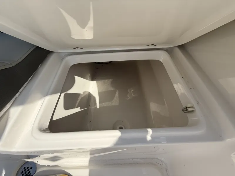 Slide: The Image of An open storage compartment on a 2027 Key West 203 FS boat, featuring a drain at the bottom. - 13