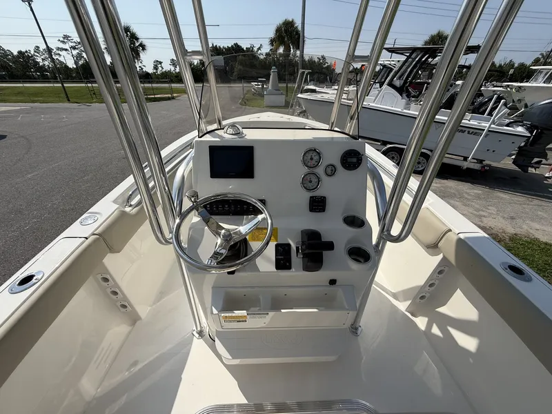 Slide: The Image of The image shows the helm of a Key West 203 FS boat with instruments and a steering wheel. - 12