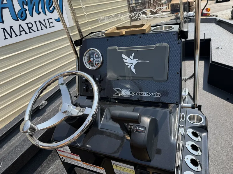 Slide: The Image of The image shows the helm of an Xpress Hyper-Lift Bay Series H24B-CUSTOM SEADECK INCOMMING! boat with a shiny steering wheel. - 7