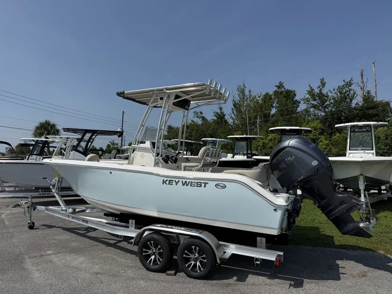 Slide: The Image of A 2027 Key West 203 FS boat on a trailer. It features an outboard motor and a T-top. - 2