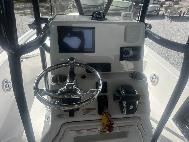 Slide: The Image of The image shows the helm of a Blazer PureBay 2400 boat with a steering wheel and electronic displays. - 11