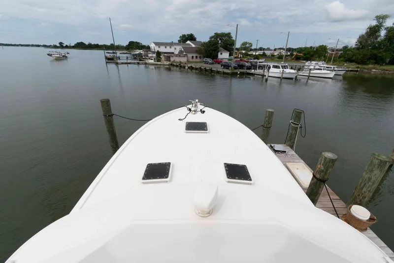 Slide: The Image of Bow view of a 1970 Hatteras 45 Convertible docked at a marina. - 4