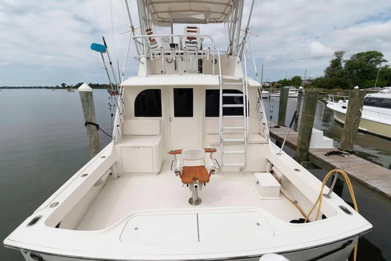 Slide: The Image of 1970 Hatteras 45 Convertible yacht docked, featuring spacious deck and fishing chair. - 2