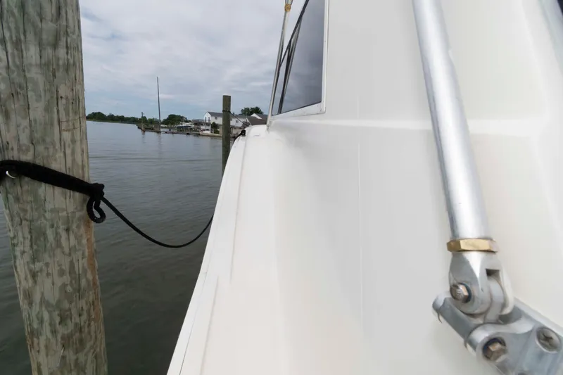 Slide: The Image of 1970 Hatteras 45 Convertible yacht docked by wooden pier, calm waters. - 12