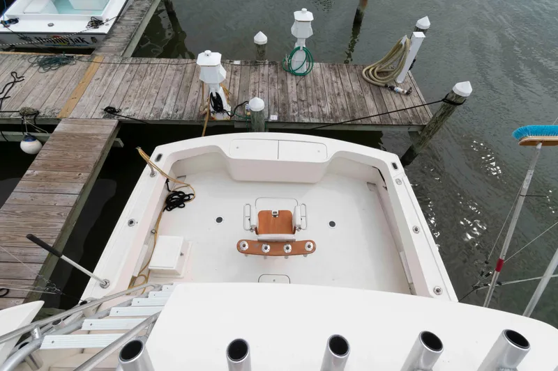 Slide: The Image of 1970 Hatteras 45 Convertible boat docked, featuring spacious deck and fishing chair. - 11