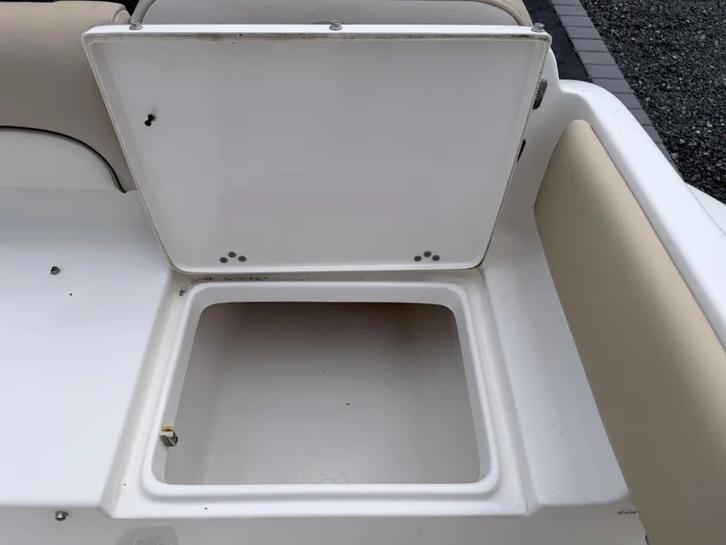 Slide: The Image of An open storage compartment on a boat with beige upholstery and a white deck. - 27