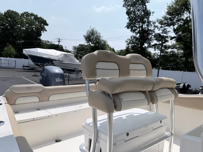 Slide: The Image of A 2014 Key West 219 FS boat with beige cushioned seats and a Yamaha 150 engine. - 17