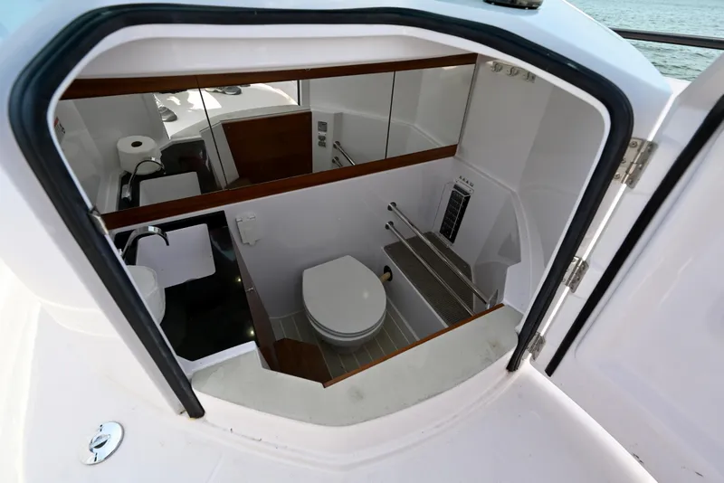 Slide: The Image of Interior view of 2021 Axopar 28 Cabin boat bathroom with toilet and sink. - 4