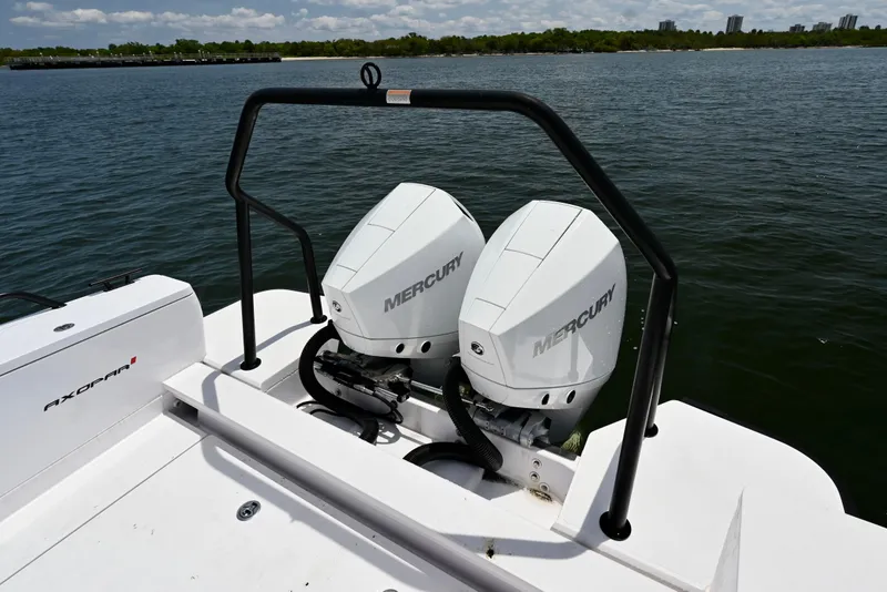 Slide: The Image of 2021 Axopar 28 Cabin boat with dual Mercury outboard engines on a calm lake. - 3