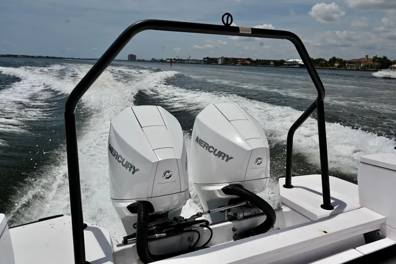 Slide: The Image of 2021 Axopar 28 Cabin with twin Mercury engines cruising on open water. - 5