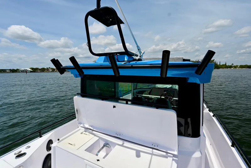 Slide: The Image of 2021 Axopar 28 Cabin boat on water, featuring blue roof and rod holders. - 1