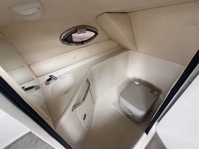 Slide: The Image of The image shows a compact boat cabin with a sink, small window, and portable toilet. - 24