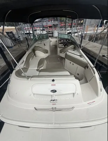 Slide: The Image of A 2006 Sea Ray 240 Sundeck with spacious cockpit and comfortable seating, under a black canopy. - 14