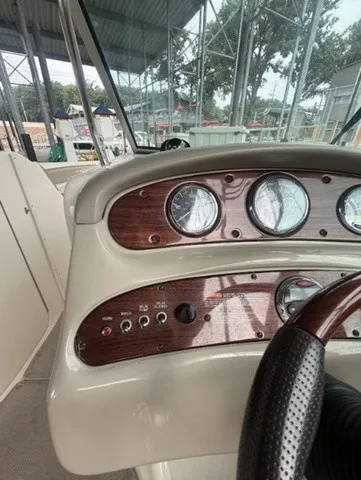 Slide: The Image of The image shows the dashboard of a 2006 Sea Ray 240 Sundeck with wood accents. - 21