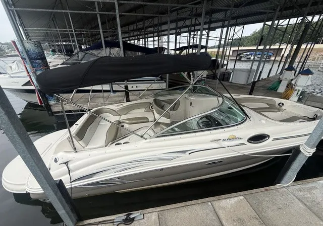 Slide: The Image of A 2006 Sea Ray 240 Sundeck is docked under a covered area. It features a black canopy. - 7
