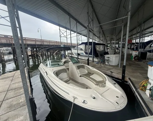 Slide: The Image of A 2006 Sea Ray 240 Sundeck is docked in a covered marina. It features an open deck design. - 5
