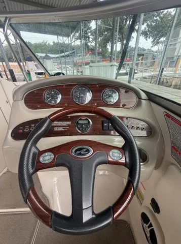 Slide: The Image of The image shows the cockpit of a 2006 Sea Ray 240 Sundeck with a sleek steering wheel and dashboard. - 22