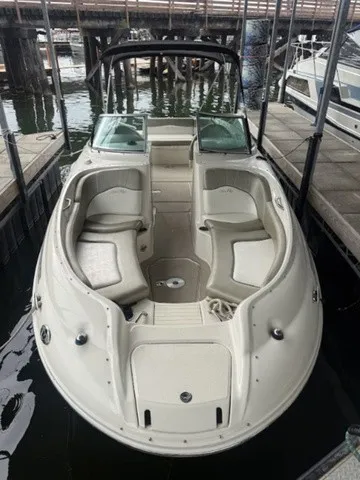 Slide: The Image of A 2006 Sea Ray 240 Sundeck docked. It features open seating and a black canopy. - 4