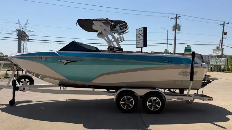 Slide: The Image of A 2021 Tigé Z3 boat on a trailer, parked in an urban setting. - 6