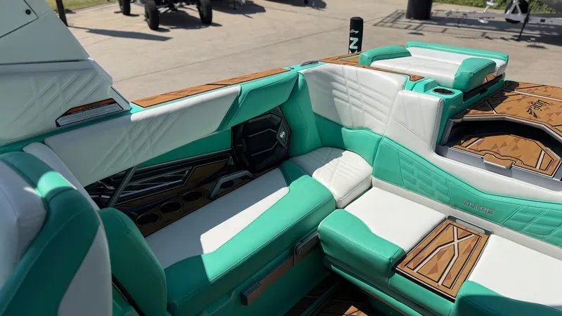 Slide: The Image of The image shows the interior of a 2025 Tigé Ultré 23ZX boat with turquoise and white seating. - 14