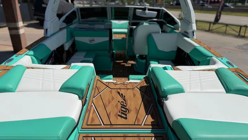Slide: The Image of The image shows the interior of a 2025 Tigé Ultré 23ZX boat with turquoise and white seating. - 11