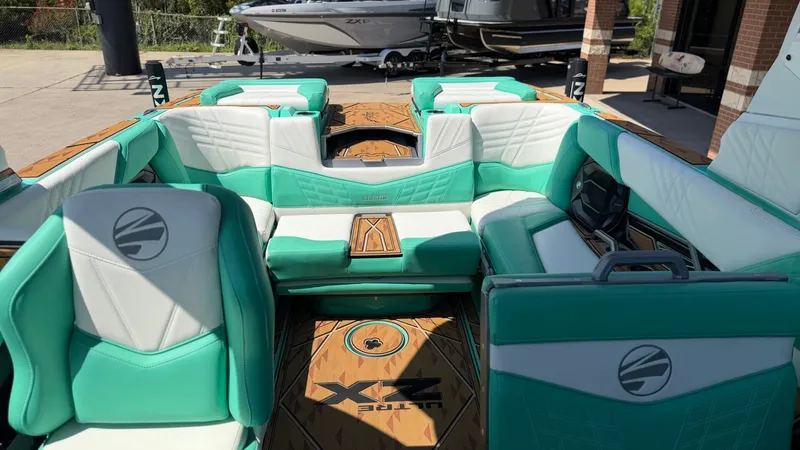 Slide: The Image of The image shows the interior of a 2025 Tigé Ultré 23ZX boat with turquoise and white seating. - 29