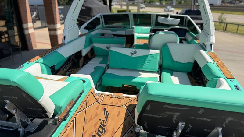 Slide: The Image of The image shows the interior of a Tigé Ultré 23ZX boat with turquoise seating and wood flooring. - 17