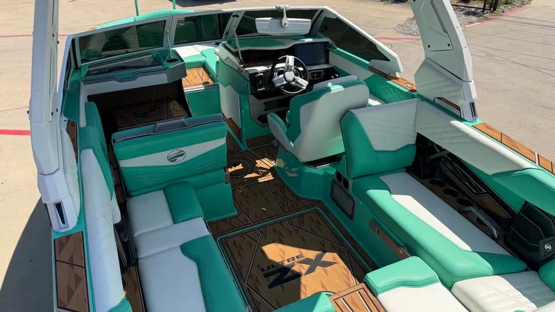 Slide: The Image of The image shows the interior of a 2025 Tigé Ultré 23ZX boat with turquoise seating. - 12