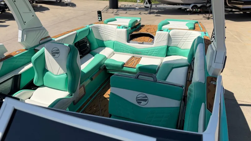 Slide: The Image of The image shows the interior of a 2025 Tigé Ultré 23ZX boat with turquoise and white seating. - 28