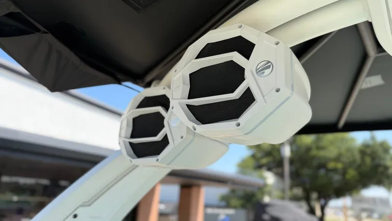 Slide: The Image of Two white speakers are mounted on a boat frame, surrounded by a sunny outdoor setting. - 30