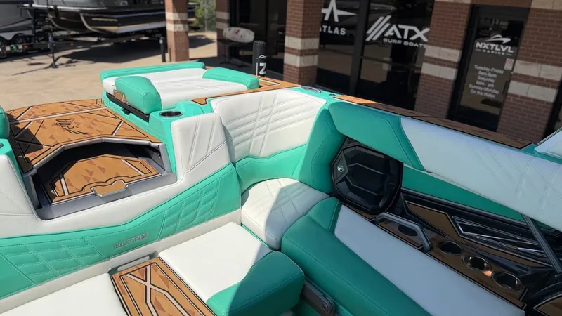 Slide: The Image of The image shows the luxurious interior of a 2025 Tigé Ultré 23ZX boat with turquoise and white seating. - 15