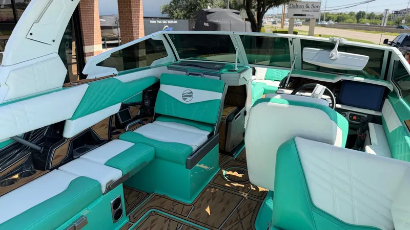 Slide: The Image of The interior of a modern boat with turquoise and white seating and a sleek dashboard. - 31
